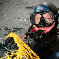 Photograph of scuba-diver with a net of shellls