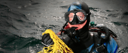 Photograph of scuba-diver with a net of shellls